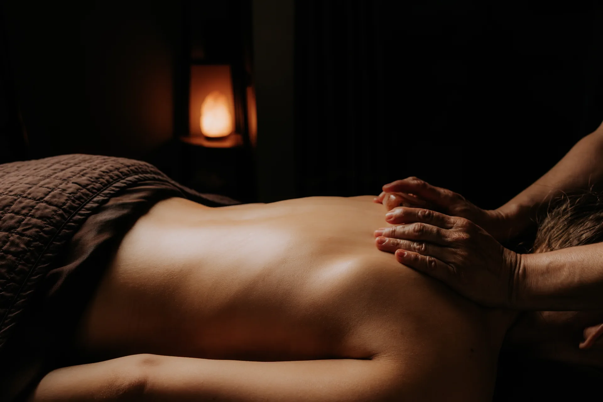 Spavia signature massage treatment in a moody candlelit treatment room